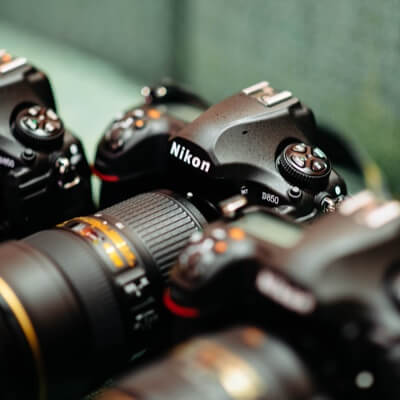 a close up shot of a trio of Nikon cameras